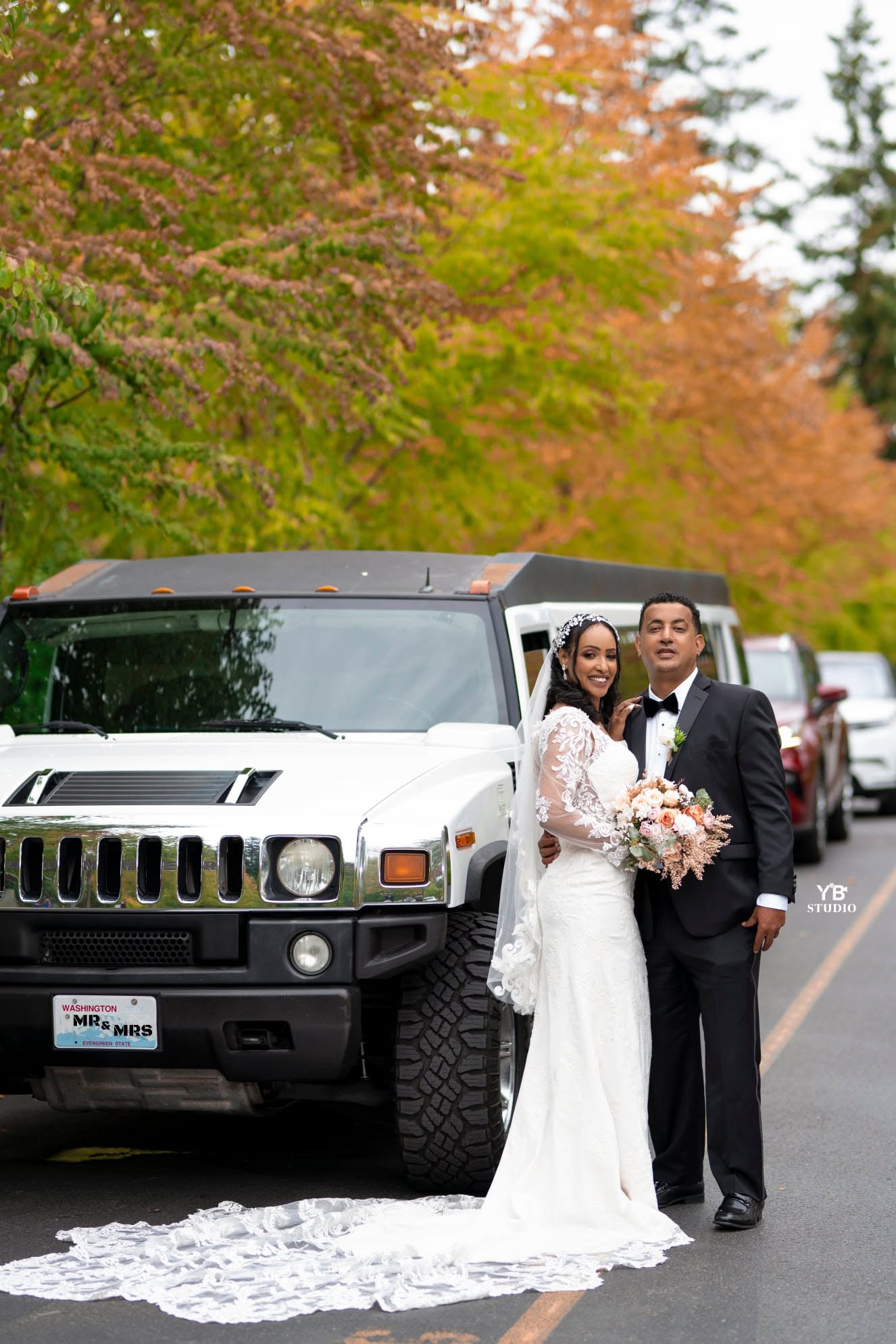 Bride and groom beside a Mr & Mrs Hummer limousine
