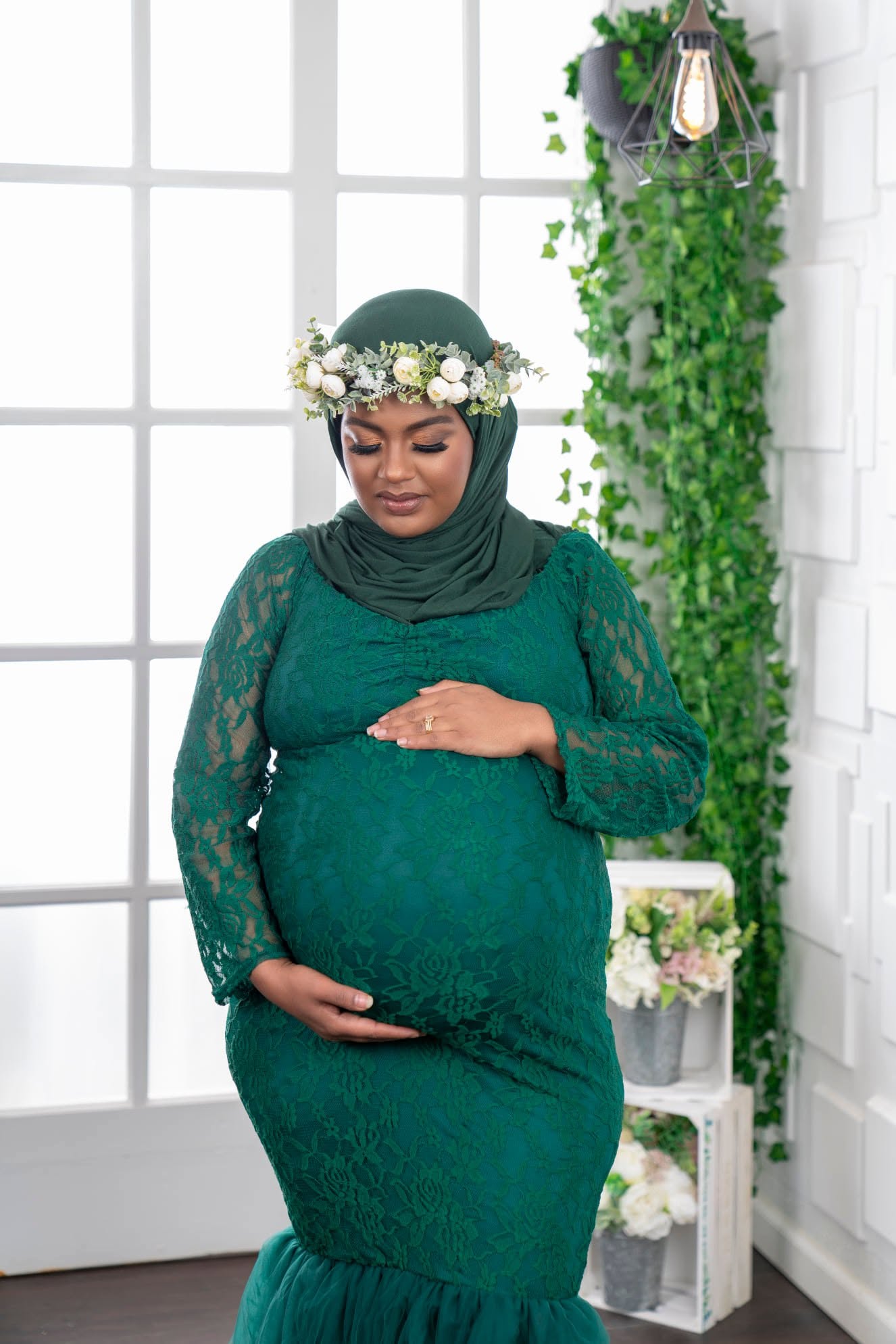 Expectant mother in an emerald lace gown and floral crown